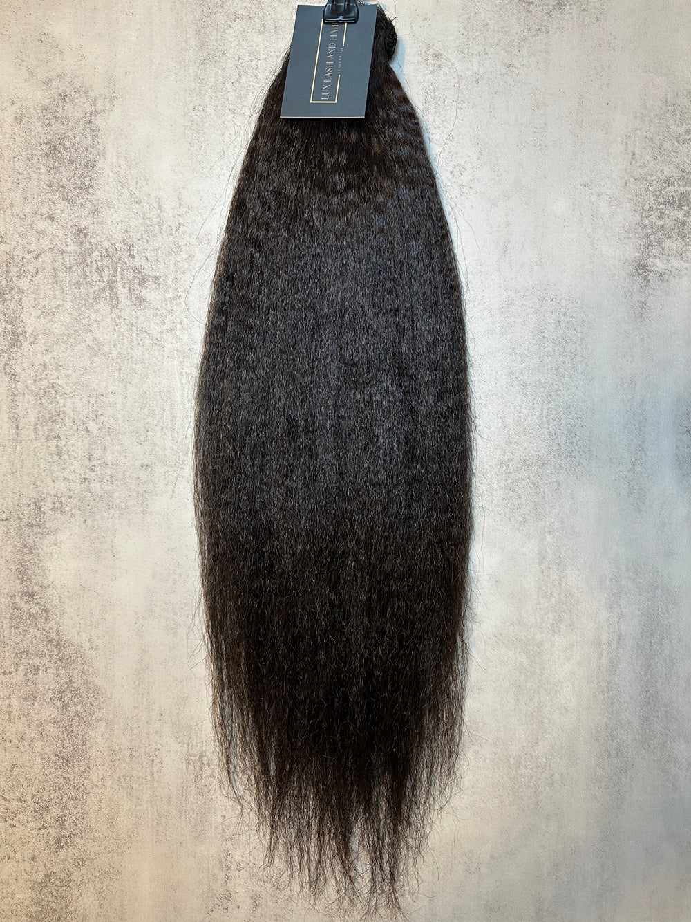 Raw Kinky Straight Clip-In Ponytail Extension – natural black, 100% raw Cambodian hair, thick texture, displayed with product tag.