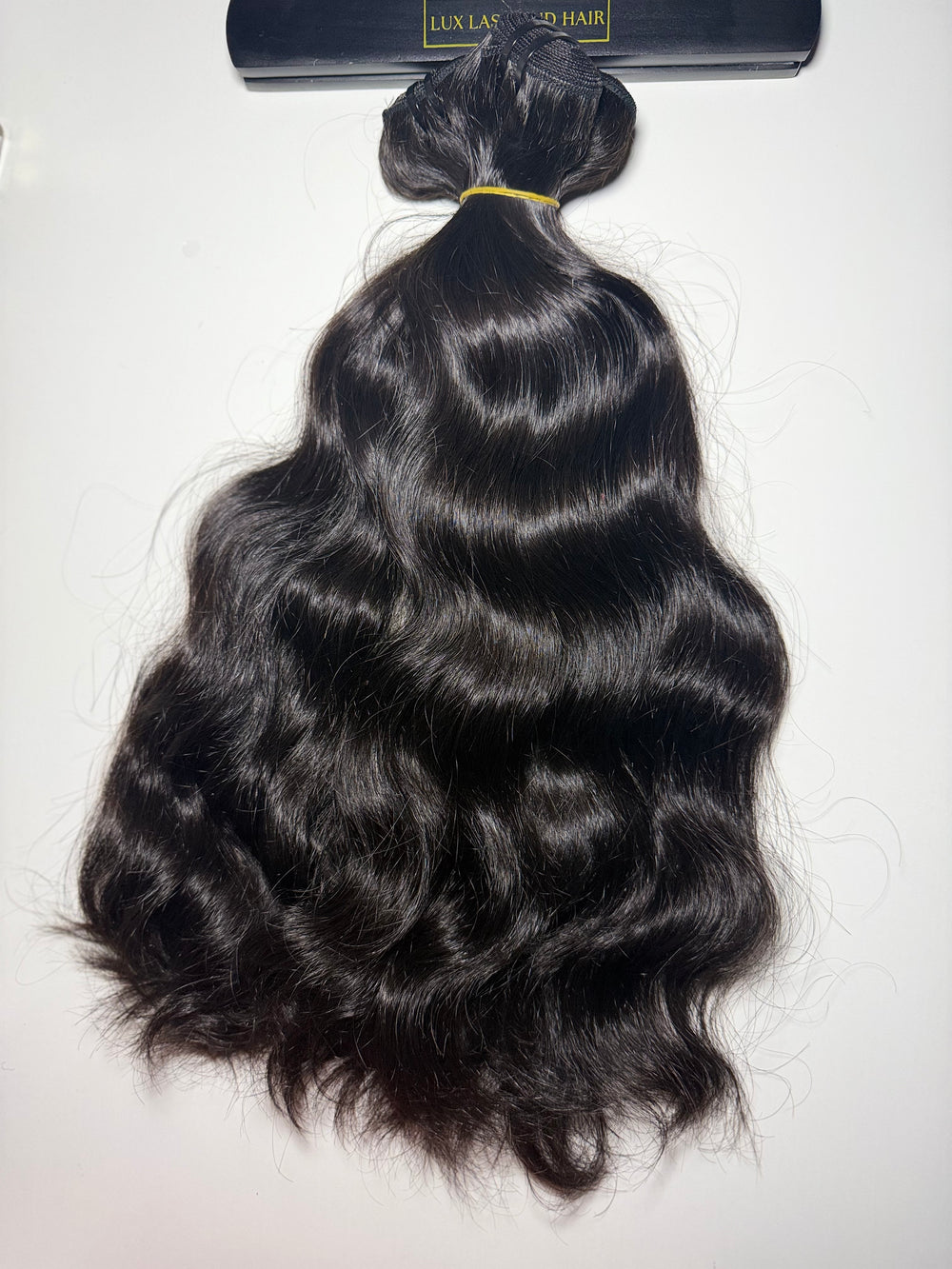 Raw natural wave human-hair bundle with soft S-waves, rich luster, and full ends displayed on white background — Lux Lash and Hair.
