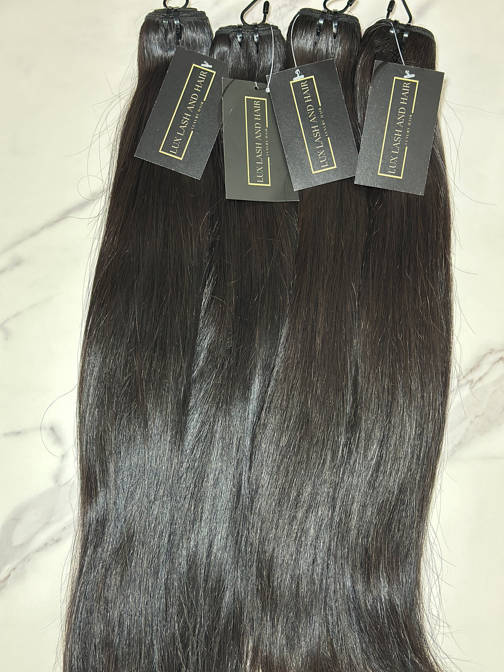 Four bundles of Raw Vietnamese Straight Hair with Lux Lash and Hair tags, premium silky texture, natural black color, displayed on white background
