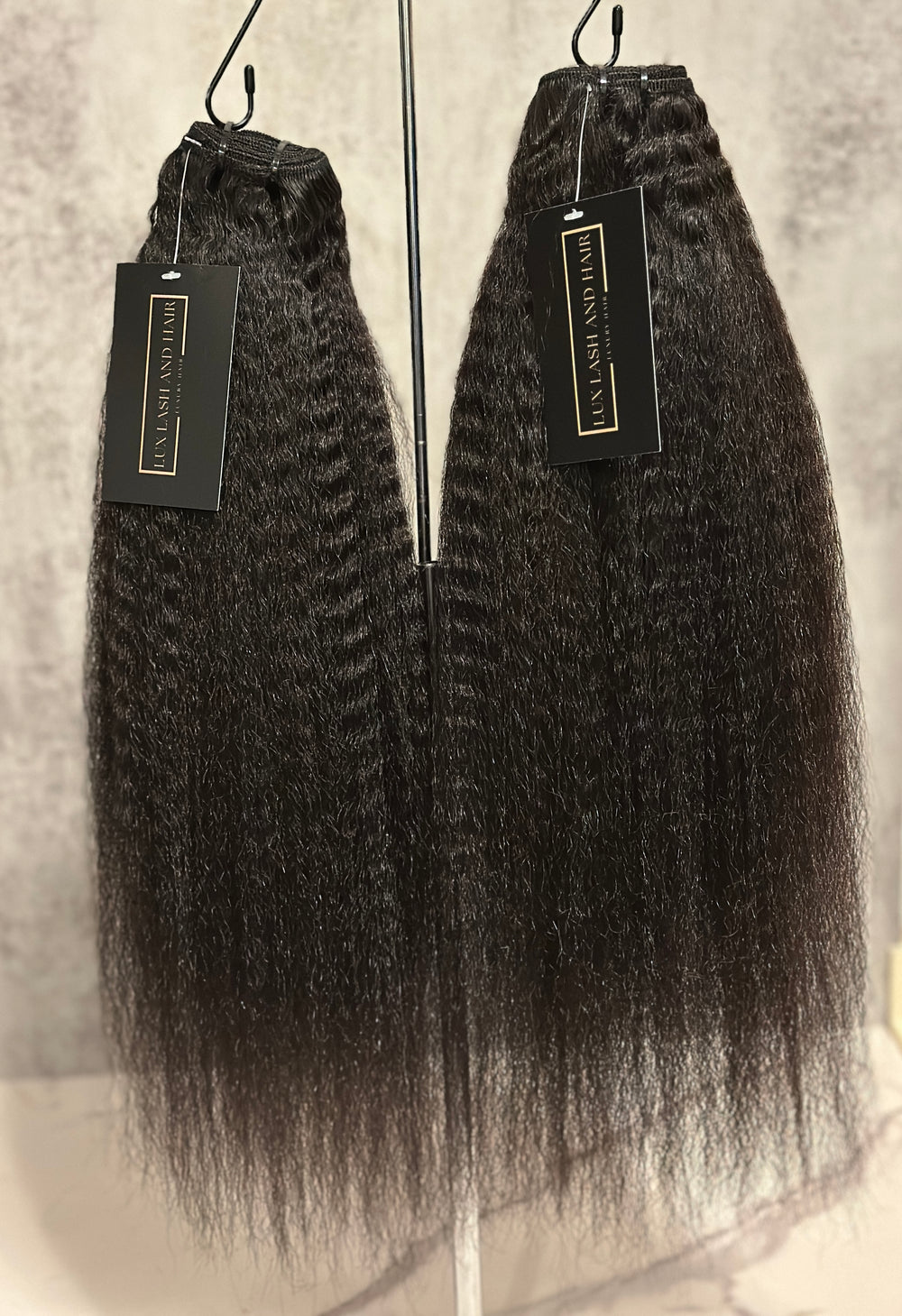 Two Lux Lash and Hair Raw Cambodian Kinky Straight bundles on display, showing coarse texture and natural fullness from root to tip.