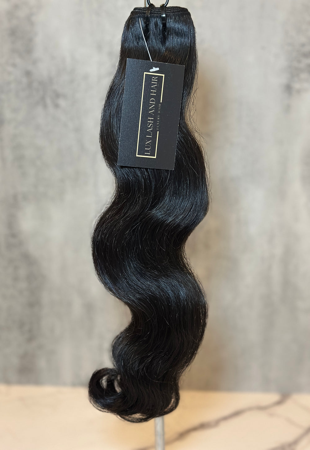 Single bundle of Lux Lash and Hair Raw Cambodian Natural Wave hair extensions, medium to dark brown, unprocessed and double drawn, displayed with brand tag.