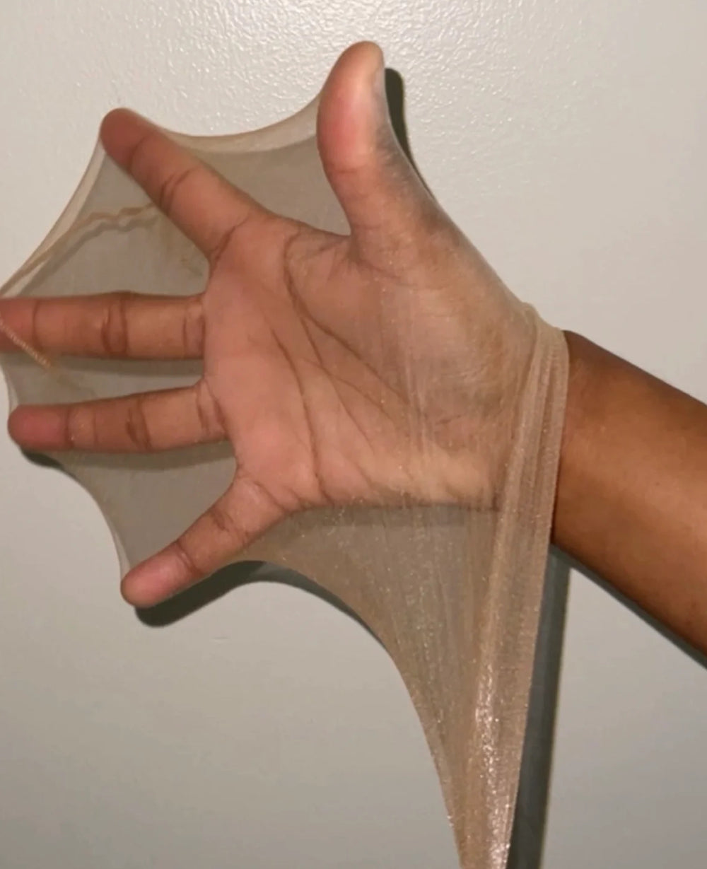 Hand stretching a premium HD wig cap to show ultra-thin, stretchable stocking fabric.