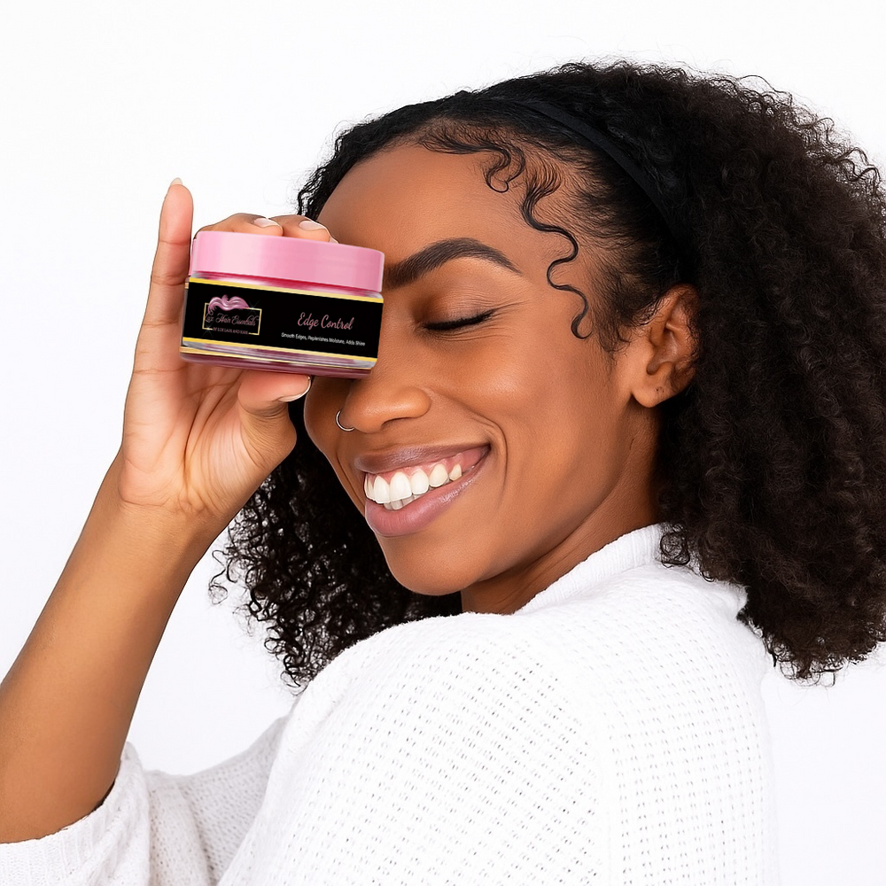 Smiling woman with natural curly hair holding a jar of Lux Lash and Hair edge control against her face.