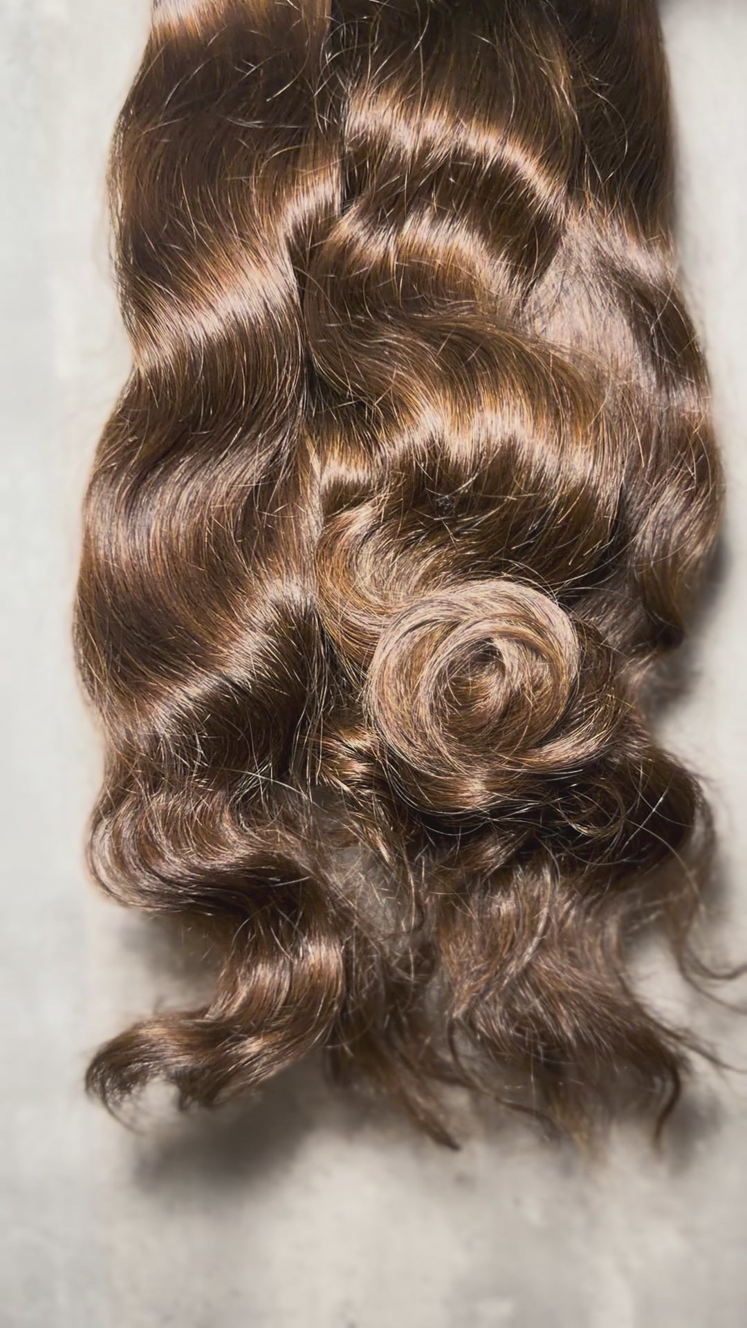 Video of Lux Lash and Hair Brown Sugar Luxe natural wave 3-bundle set in 16” and 18” lengths displayed on marble background.